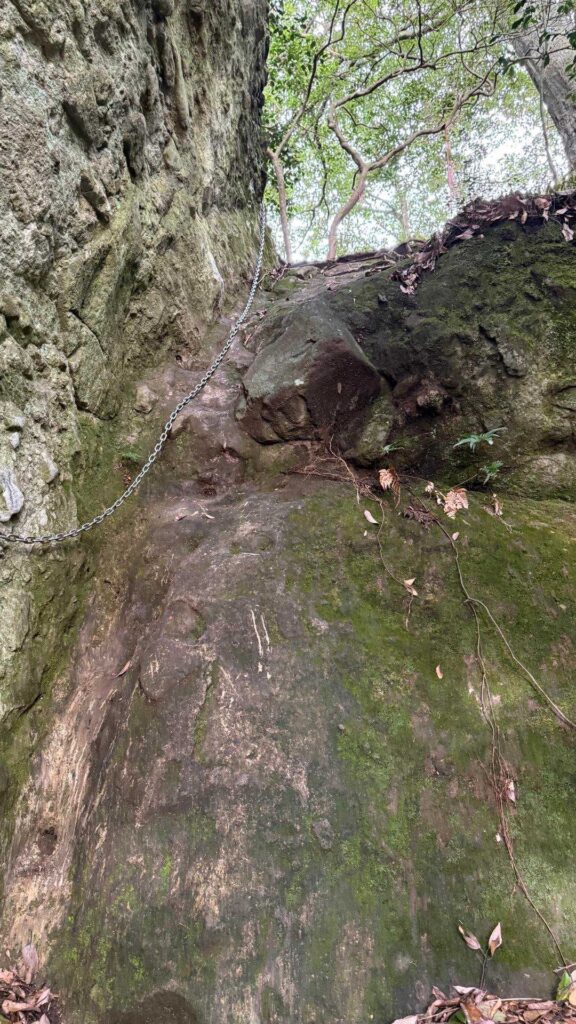 苔むした岩の隙間を登る鎖場