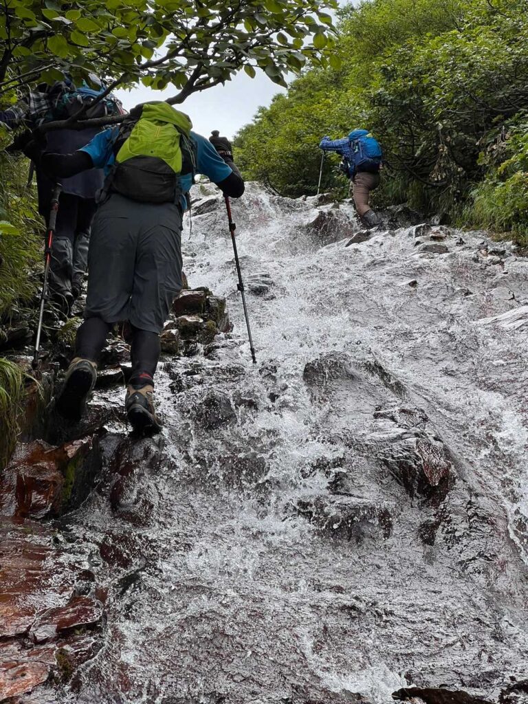 水が流れる岩場を複数人で登る