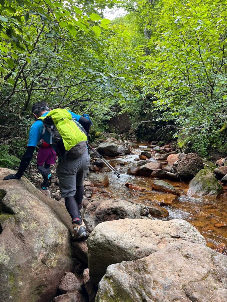 沢の岩を渡る登山者たち