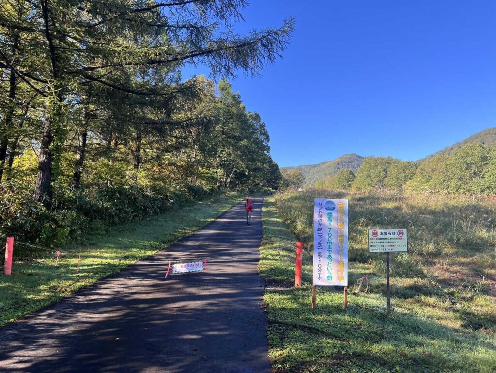 駐車場からアスファルトの道を上がっていく