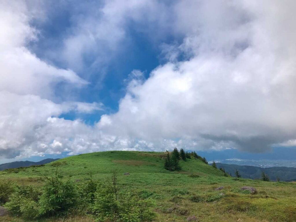 青空と雲のコントラストが美しい緑の丘