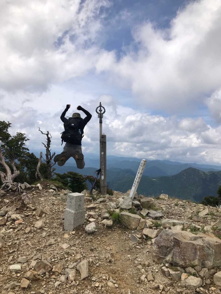 山頂で万歳ポーズ