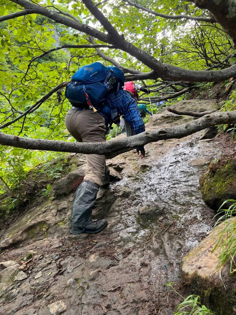 急な岩場を登る登山者