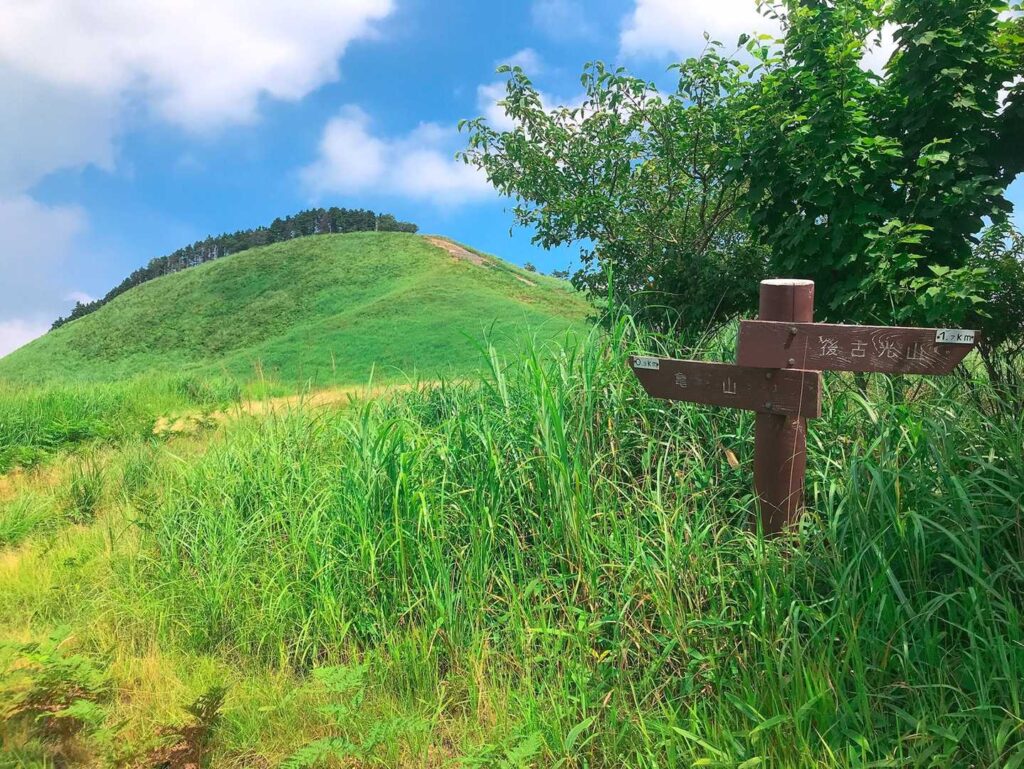 山頂標識と草原の山