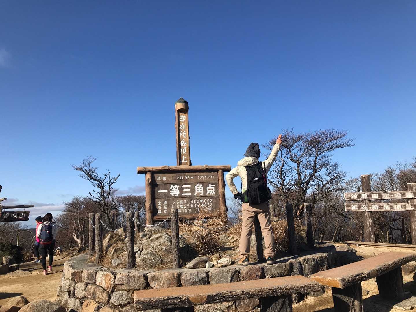 山頂で一等三角点と記念ポーズ