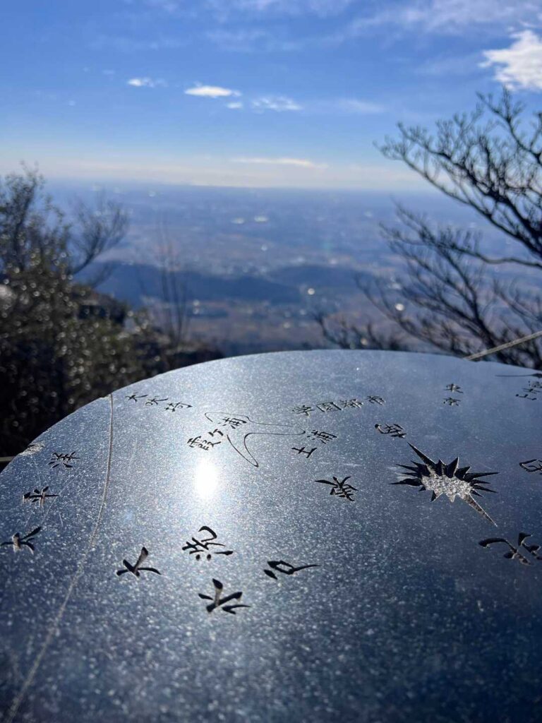 山頂の方位盤と遠くにスカイツリー🗼